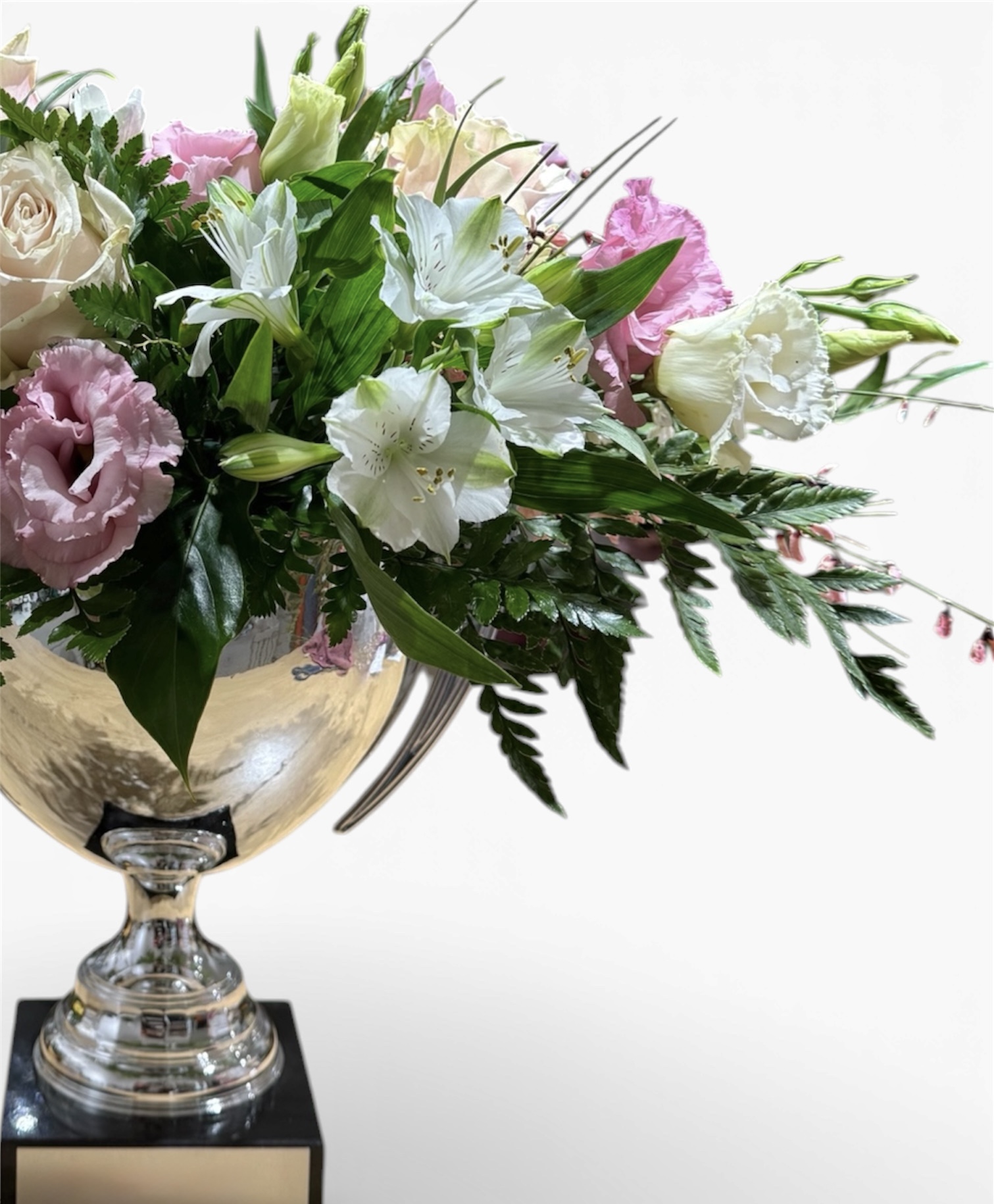 Composizione di rose e lisianthus in una coppa argentata